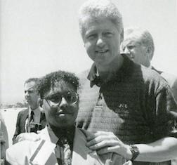 student posing with President Clinton 